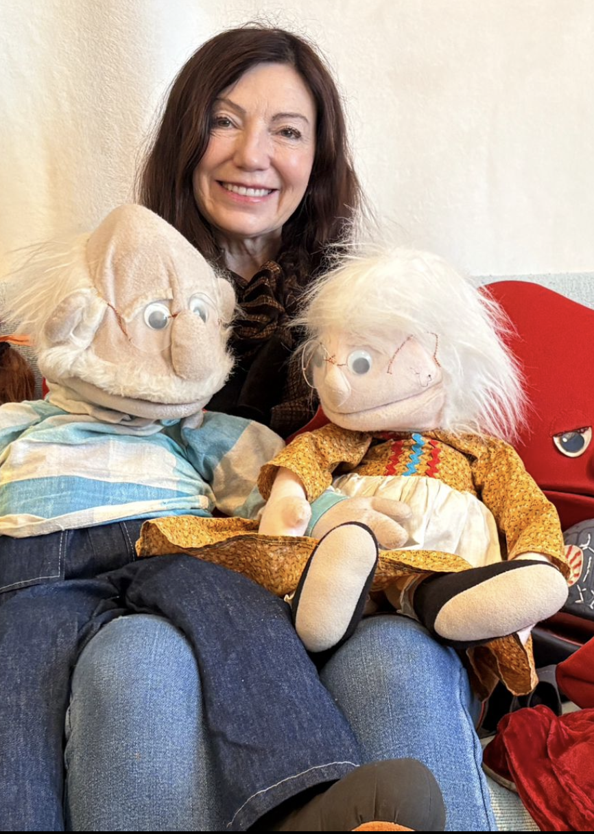 Charmaine smiling with John and Sheila, two of her puppets